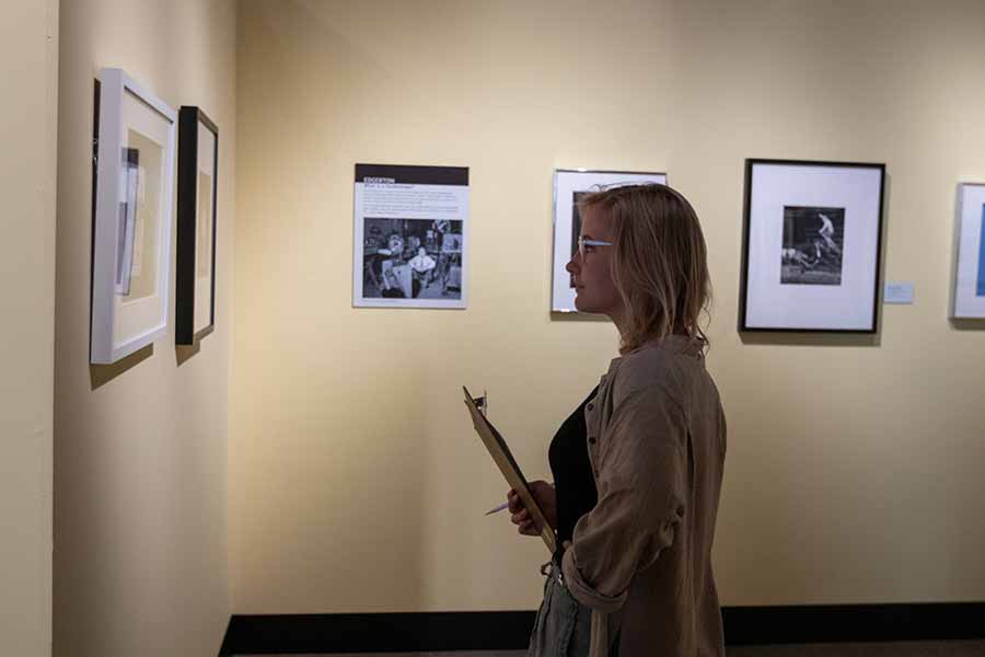 A woman reviews art work in a gallery
