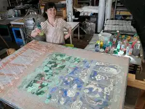 Muriel Condon standing beside handmade paper