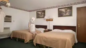 person wearing a mask sitting on a hotel bed