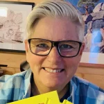 Photo of Paige Braddock holding books in an office