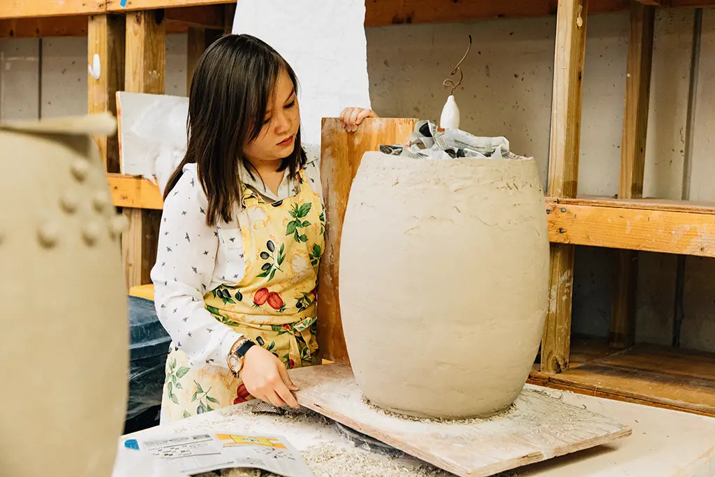 A young woman working on a pottery piece