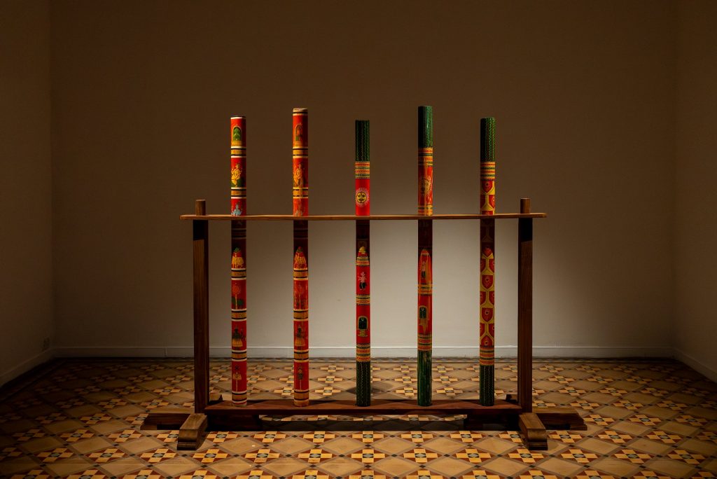 An sculpture of five painted poles 