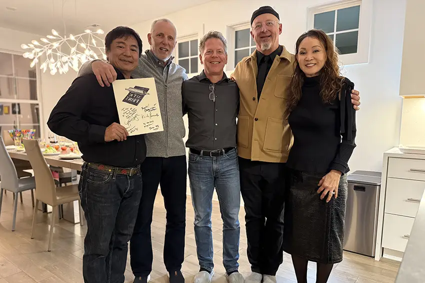 Four professors stand together for a group photo.