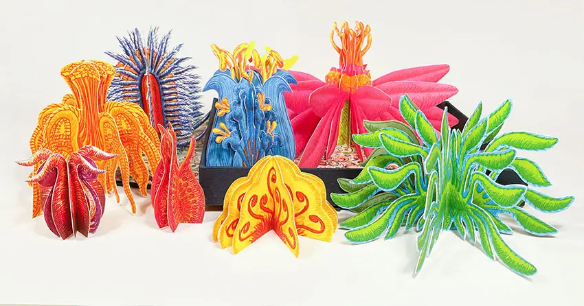 A group of various plants are displayed together featuring curled leaves and spikes. The plants are made from photopolymer. 