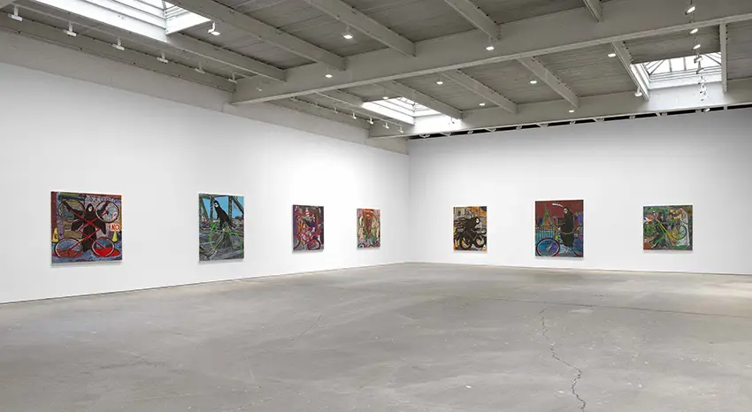 Image of seven portraits displayed in a gallery on walls. 
